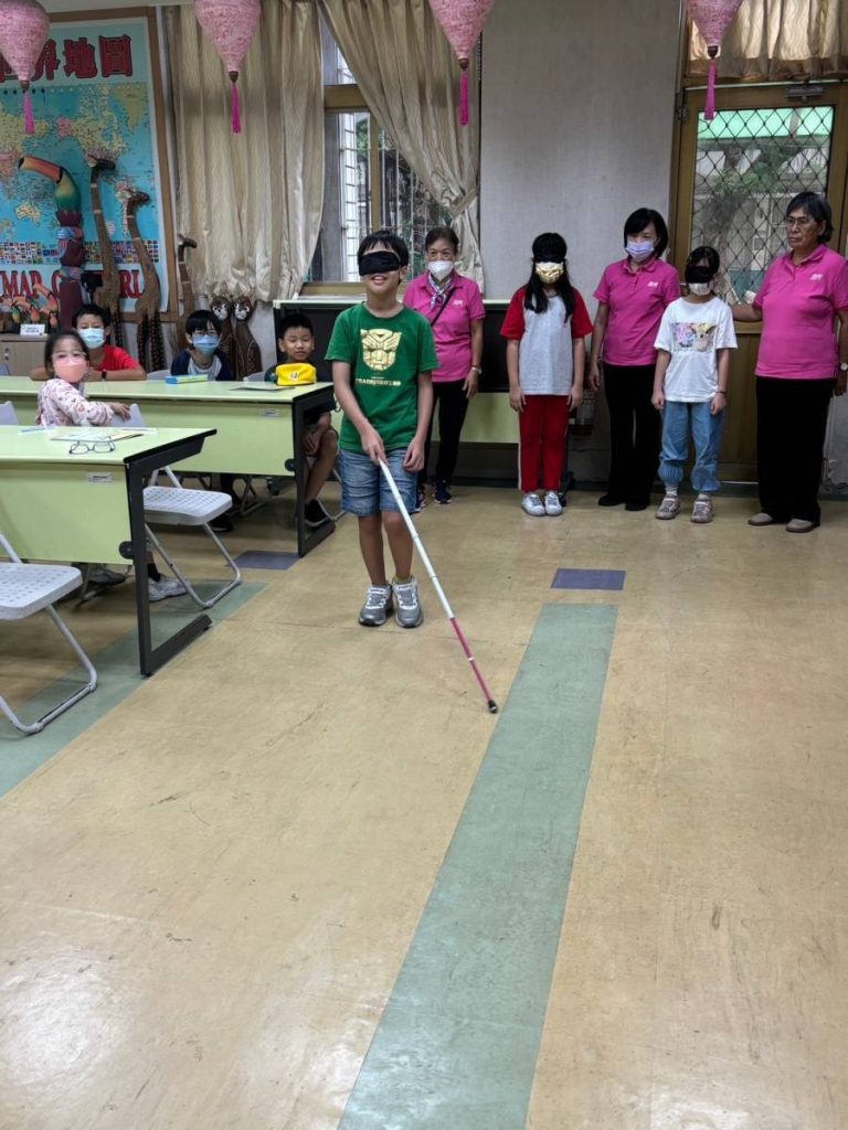 學生模擬視障者做闇黑體驗持手杖行走